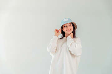 portrait of a beautiful girl in a denim round cap in a hoody on a white background. the concept of sport