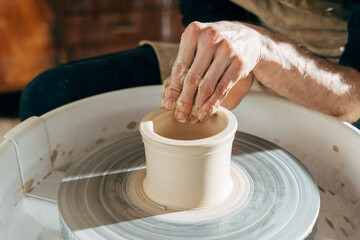 Craftsman artist shapes pot at the studio