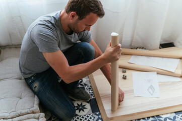 Focused man installing table at home