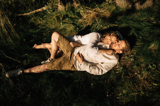 Lovely Couple Laying On Grass In Bright Sunlight