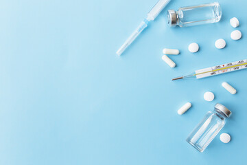 Medicine treatment, vaccination concept. Thermometer, vaccine, syringe, pills