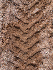Tyre trace on sand texture. Wheel tread imprints on sandy beach, abstract background. Rubber automobile tyres trail on sea shore.