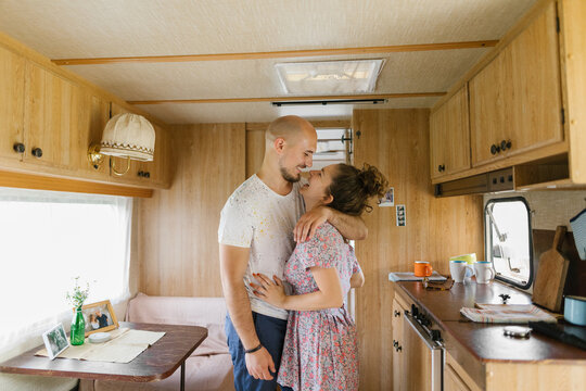 Couple hugging in a trailer