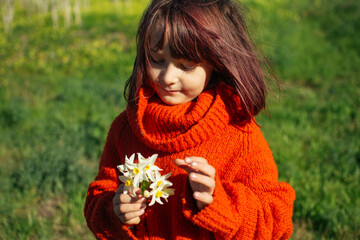 Young girl holding a bunch of small white flowers