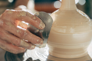 Potter modeling ceramic pot from clay on a potter's wheel