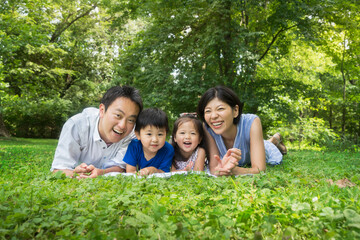 Smiley Asian family summer portrait on the grass