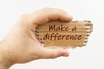 A man holds a cardboard in his hand on which it is written - Make a difference