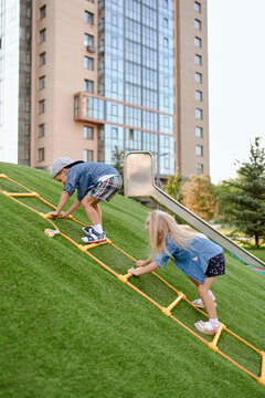 twin children play on the Playground near the house