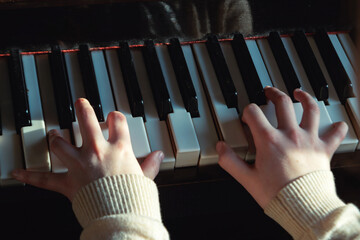 The girl plays musical reproduction on the piano.