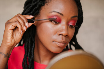 Beautiful black woman applying make up