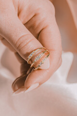Woman holding multiple rings with her finger, silky background