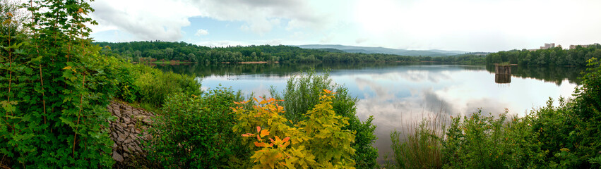 Panoramic view of a calm lake on a sunny summer day