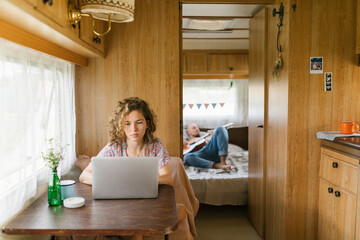 Girl working on her laptop in a trailer