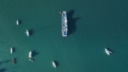 fishing vessel surrounded by yachts in pacific ocean