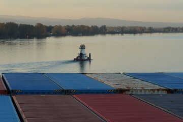 Pusher tug sailing near loaded container vessel in Columbia river in Portland, Oregon.