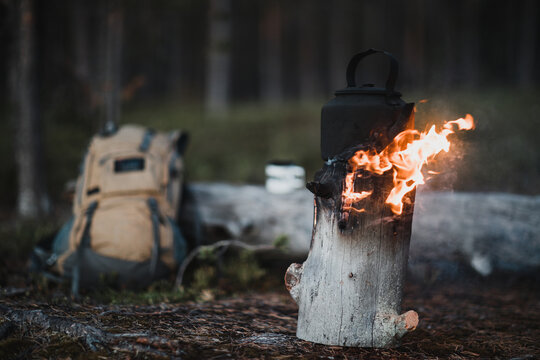 Kettle on a Finnish candle and a hiking backpack on a forest background