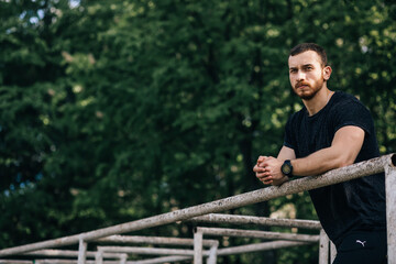 Portrait young bearded man standing on public sports ground and