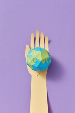 Paper handmade Earth's globe on a craft hand.