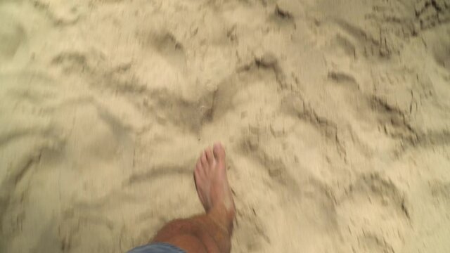 Walking bare feet in the sand at the atlantic ocean