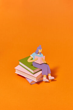 Handcraft paper girl is reading on the books.