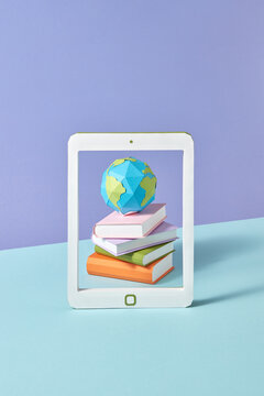 Papercraft tablet screen with books and globe.