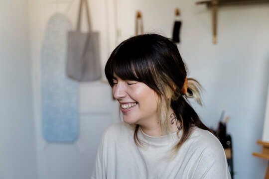 Portrait of a happy female young artist in her studio