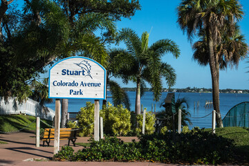 Downtown historic Stuart, FlorIda. Entrance to Colorado Avenue Park, blue river in the background, bright blue sky, no clouds, tropical palm trees. Scenes along this eastern Florida waterfront town