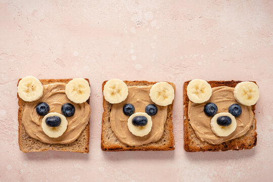 Cute bear face toasts with peanut butter, banana and blueberries