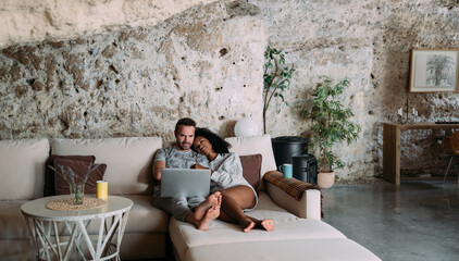 Young couple with laptop resting in modern living room