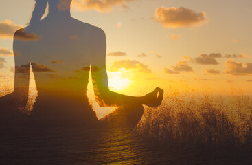 Woman meditating facing sunrise. Inner peace, and spirituality concept.  - obrazy, fototapety, plakaty