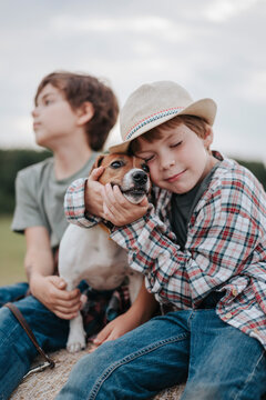 Portrait of two little brothers with dog in the field.
