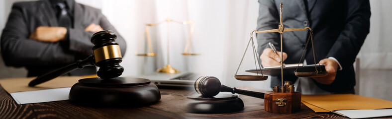 Justice and law concept.Male judge in a courtroom with the gavel, working with, computer and...