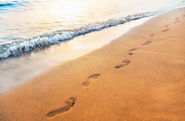 footprints on  tropical beach and beautiful  wave