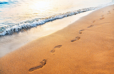 Obraz na płótnie Canvas footprints on tropical beach and beautiful wave