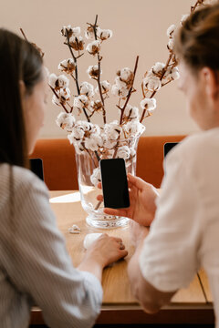 Friends discussing new app on smartphone