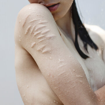 Vulnerable sensual woman standing under water