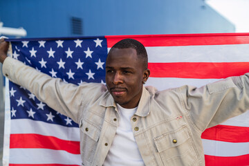 Chico negro con bandera de estados unidos en un parking