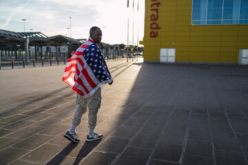 Chico negro con bandera de estados unidos en un parking
