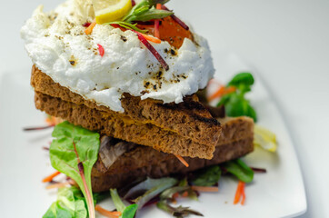 Egg in a cloud on grilled sandwiches with cumberland sausage, tomato and mayonnaise, all served with a fresh salad