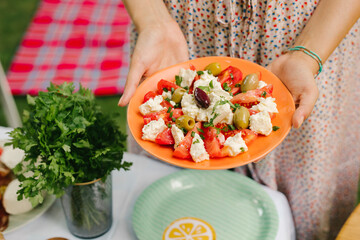 Woman holding tomato and mozzarella salad