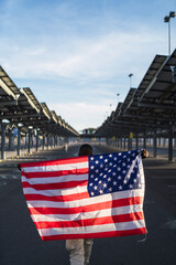 Chico negro con bandera de estados unidos en un parking