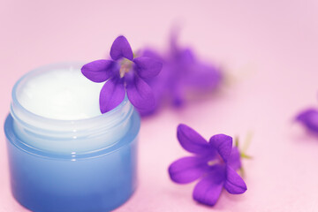 Obraz na płótnie Canvas Natural organic cosmetics. Homemade Skin Cream. Homemade Beauty Products. Natural cream and flowers on a lilac background.