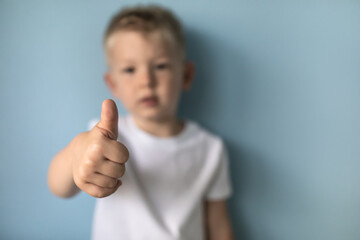Little boy showing thumbs up to camera 