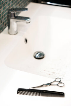 Haircut tools scissors and comb in the bathroom at home.