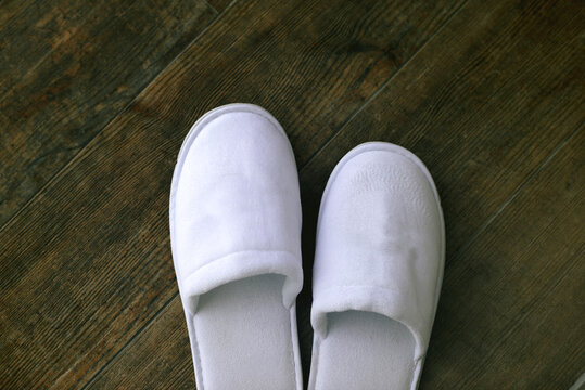 white bath slippers on wooden floor