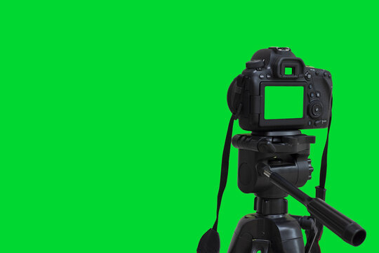 Dslr camera with green screen on the tripod isolated on green background.  Green screen camera