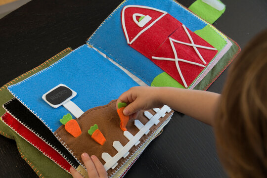 ni&ntilde;o jugando con libro educaci&oacute;n sensorial