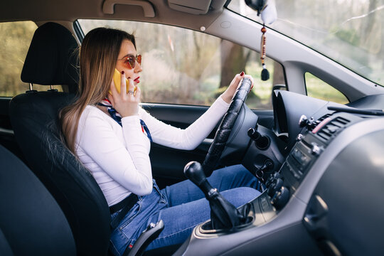 Business young woman driving car and talking on cell phone conce