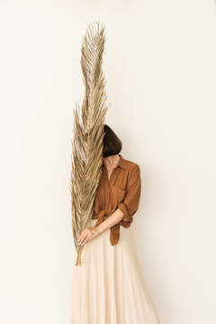 Young girl holding big palm leaf