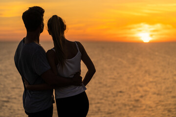 The romantic couple standing closely on the beautiful evening sky background